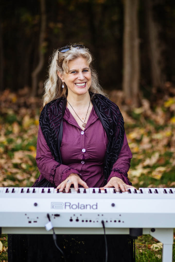 Die Musikerin Anja Cantánima spielt Keyboard und lächelt in die Kamera